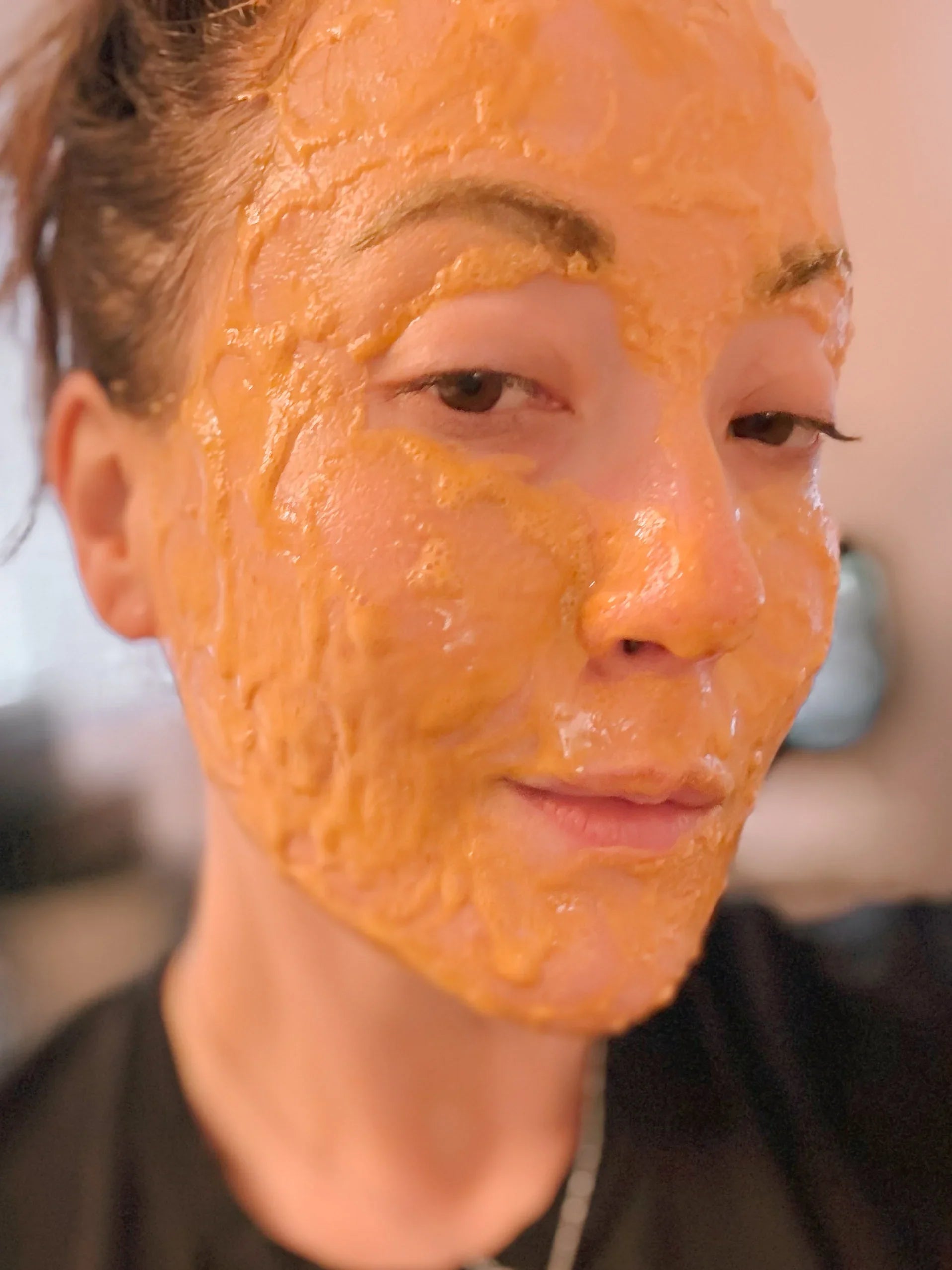 woman wearing a bubbling hydration mask. mask in orange.