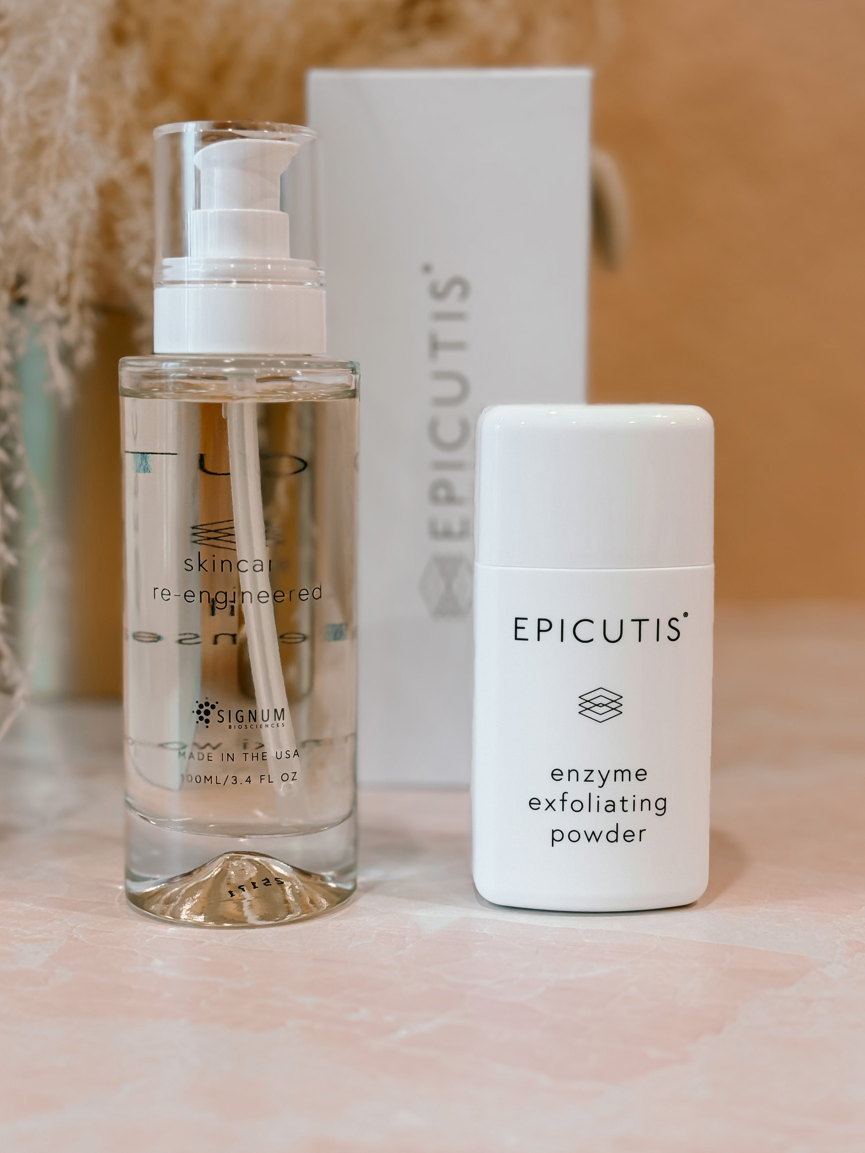 Two skincare products from Epicutis on a light surface with a blurred background. Oil cleanser and enzyme exfoliating powder.