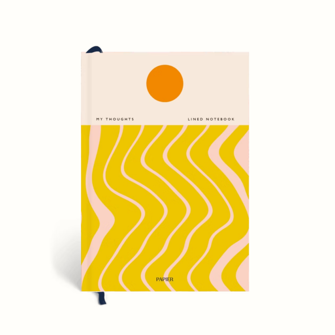 Notebook with a sun and wavy line design on a white background