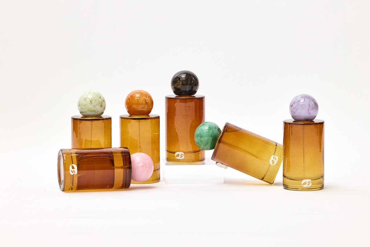 Set of glass containers with colorful spherical lids on a white background