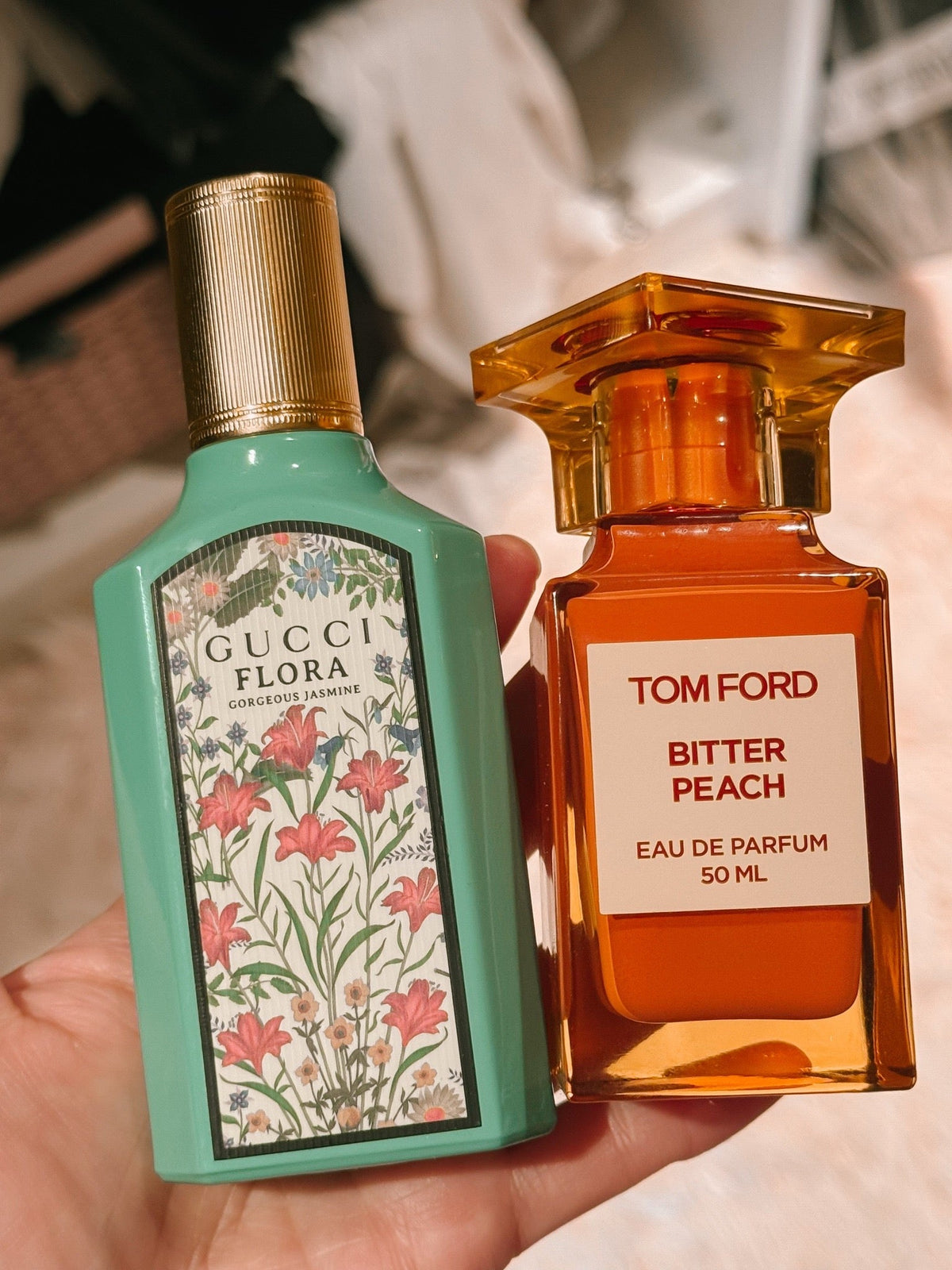 hand holding perfume bottles. Gucci and tom ford featured.