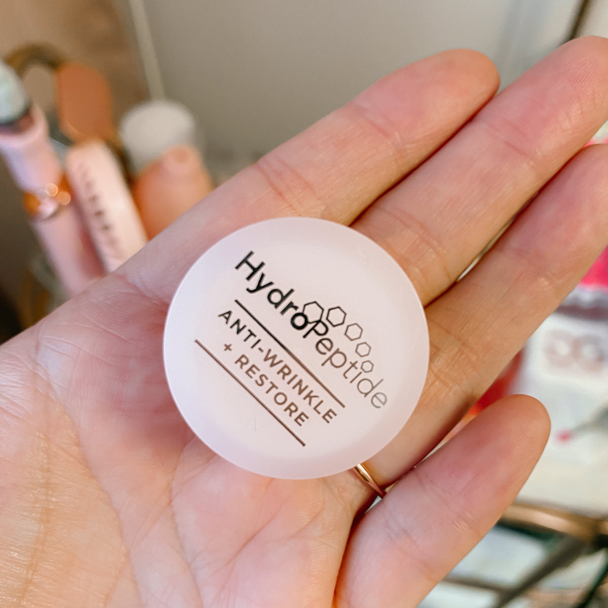 hand holding hydropeptide lip balm