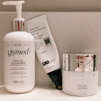 three skincare products on a mable shelf.  glymed idyllic cleanser, pca tinted spf, clinical skin moisturizer