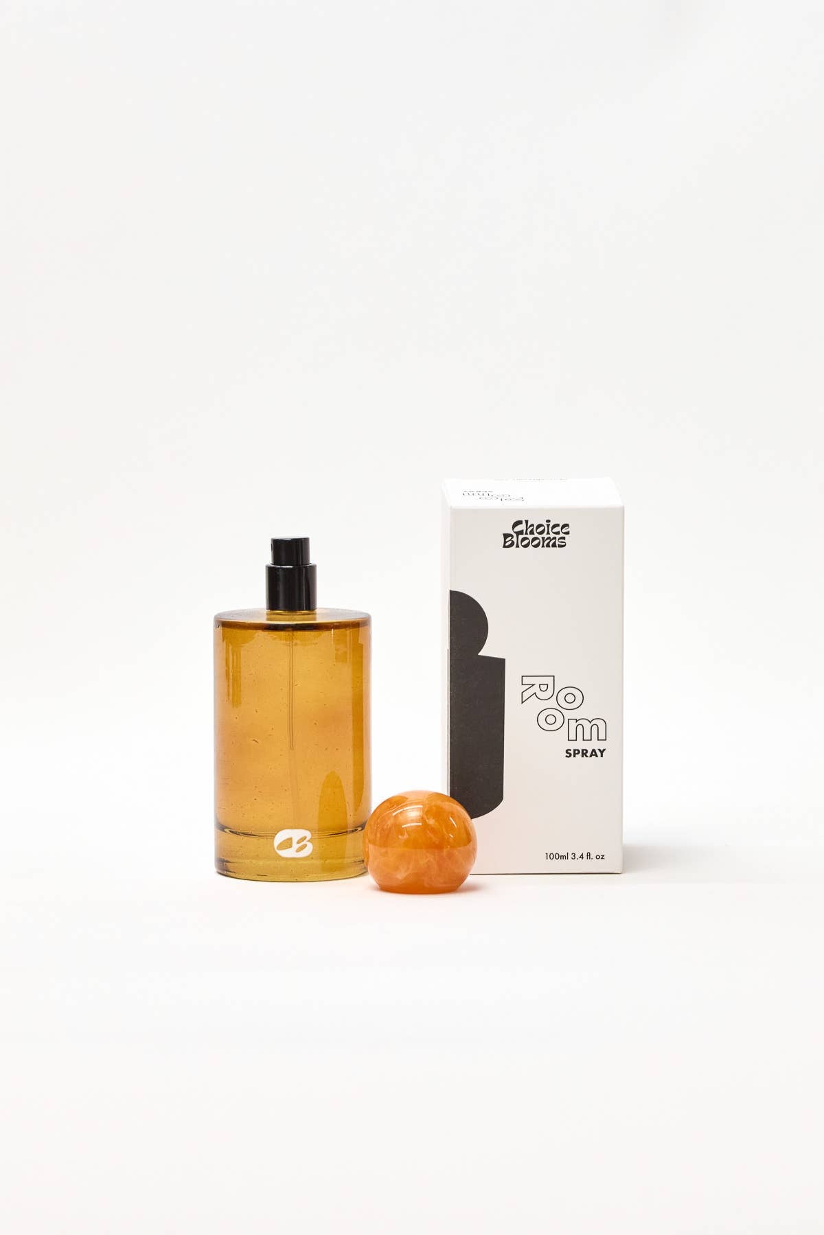 Amber-colored perfume bottle with a spherical container and packaging on a white background