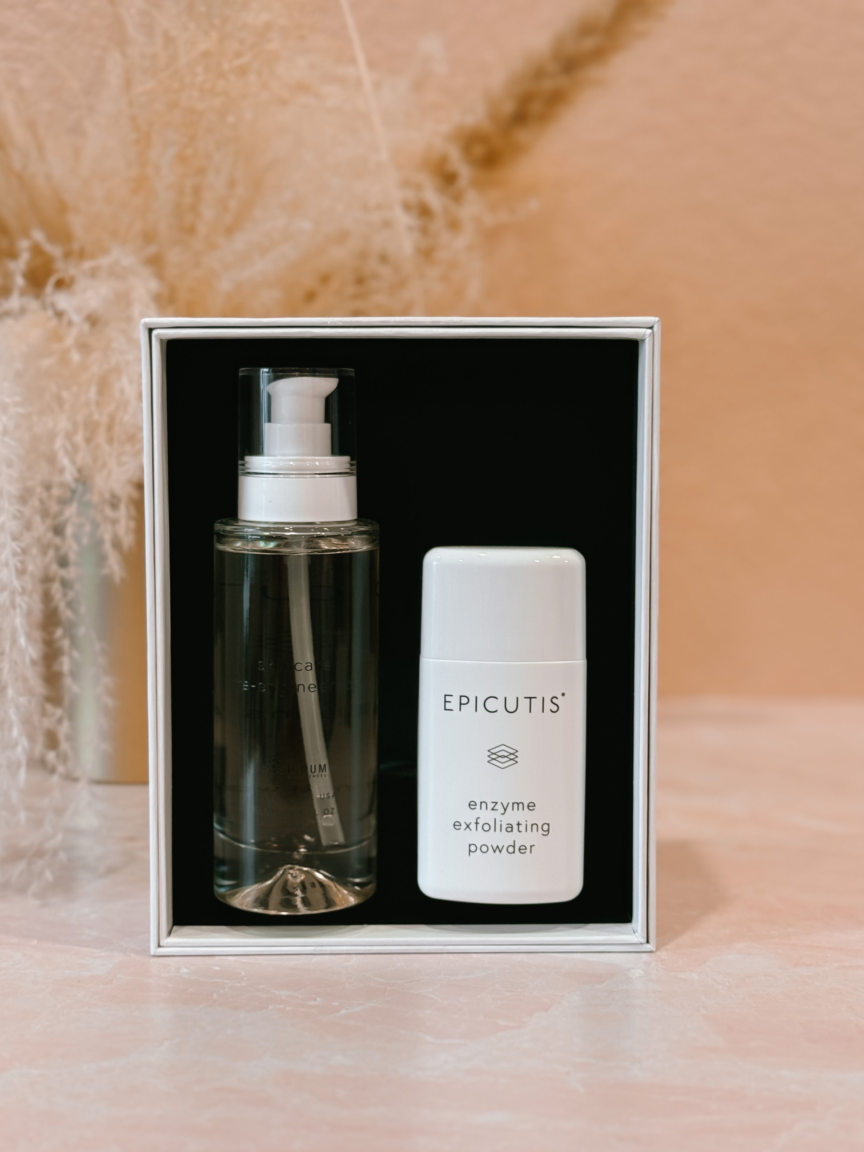 Two skincare products in a box with 'Epicutis' branding on a marble background oil cleanser and enzyme exfoliating powder. 