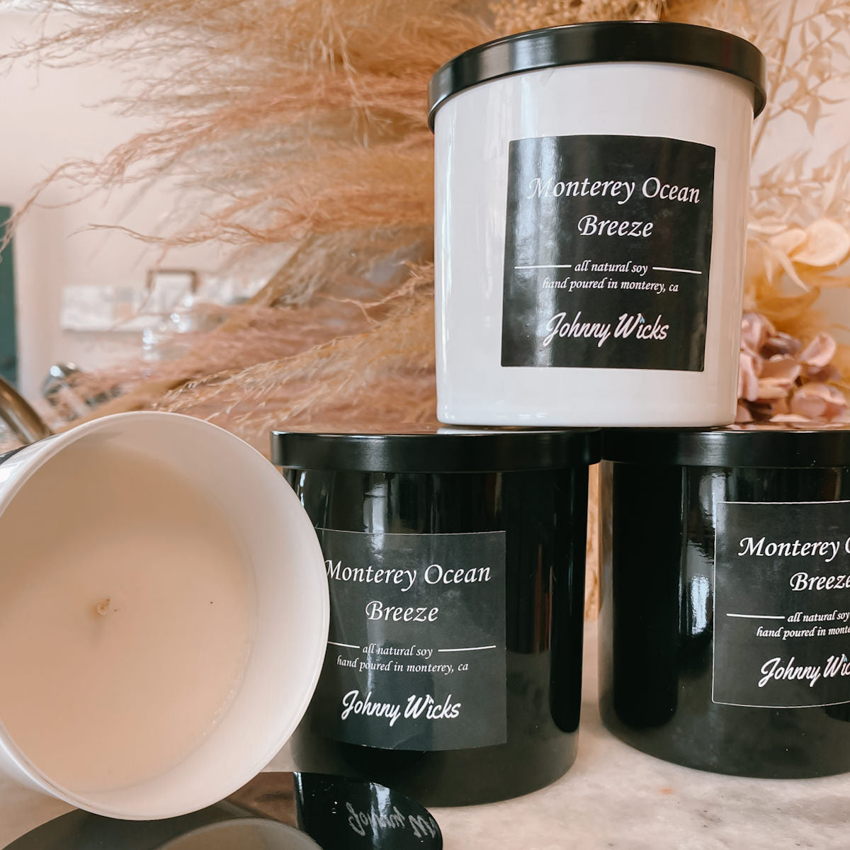 Johnny Wicks Monterey Ocean Breeze candles on a surface with decorative elements.