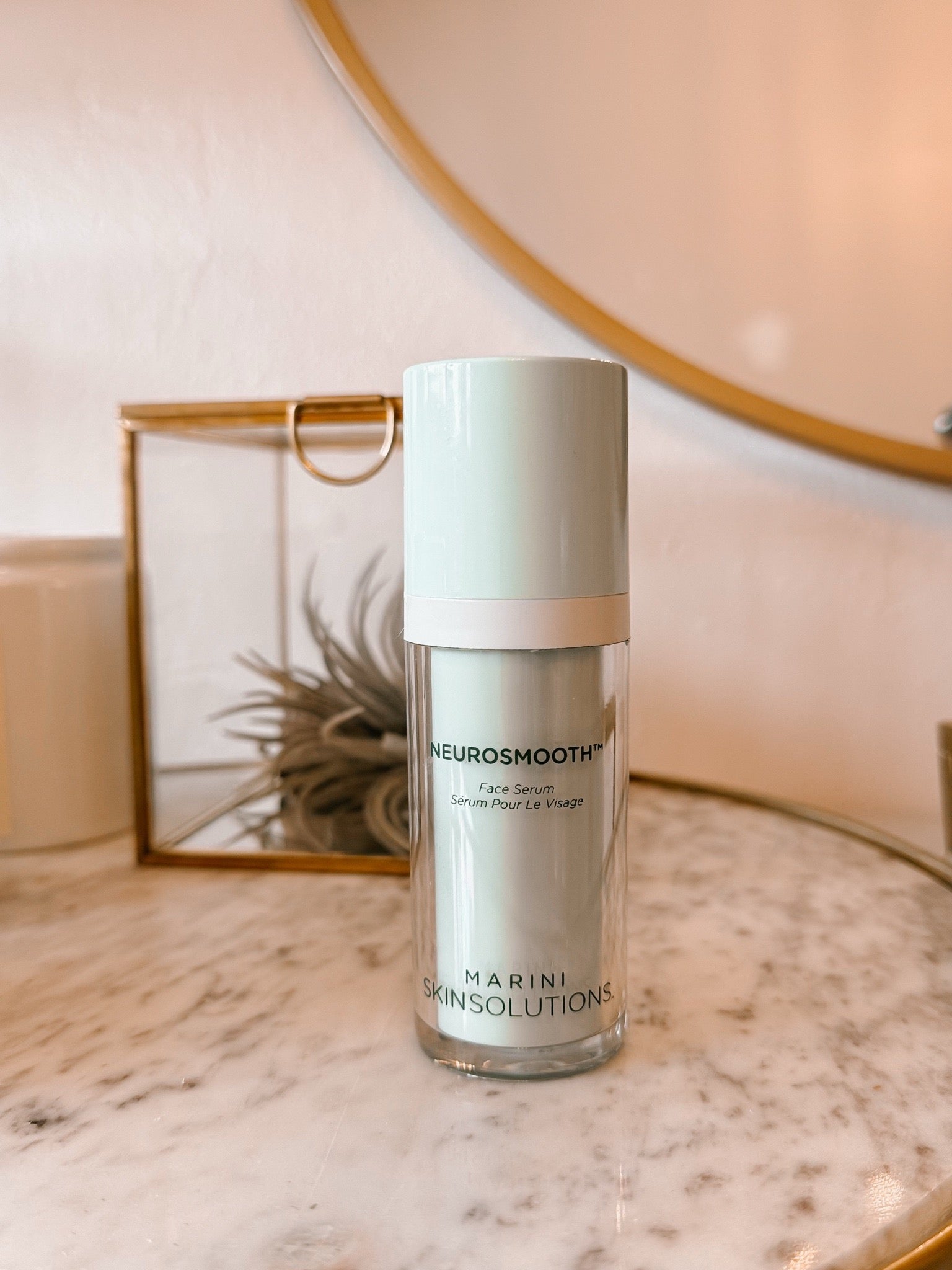 Skincare serum bottle labeled 'Neurosmooth' by Marini Skinsolutions on a marble surface.