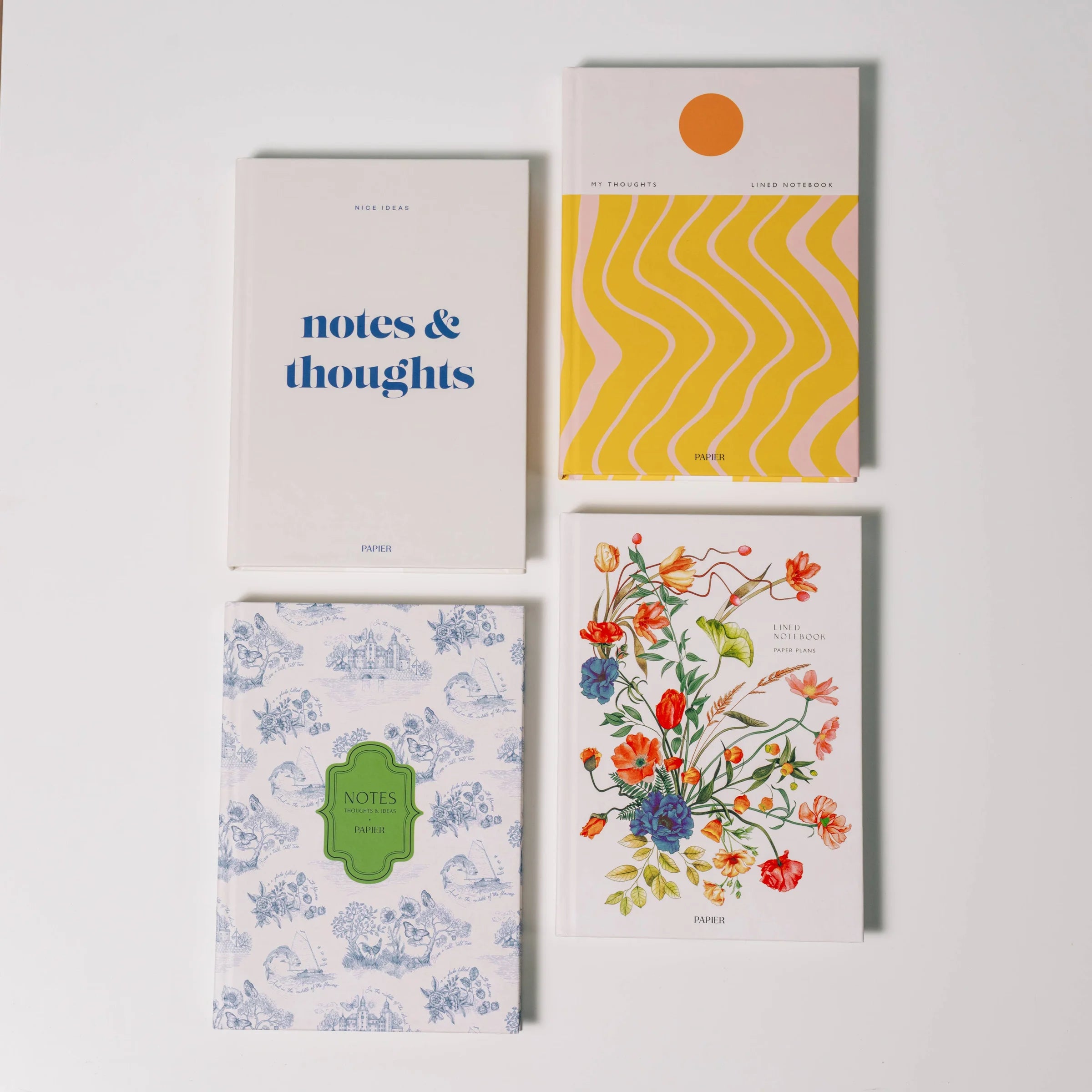 Four notebooks arranged in a 2x2 grid on a light gray background. The top-left notebook is white with blue text reading 'notes & thoughts'.