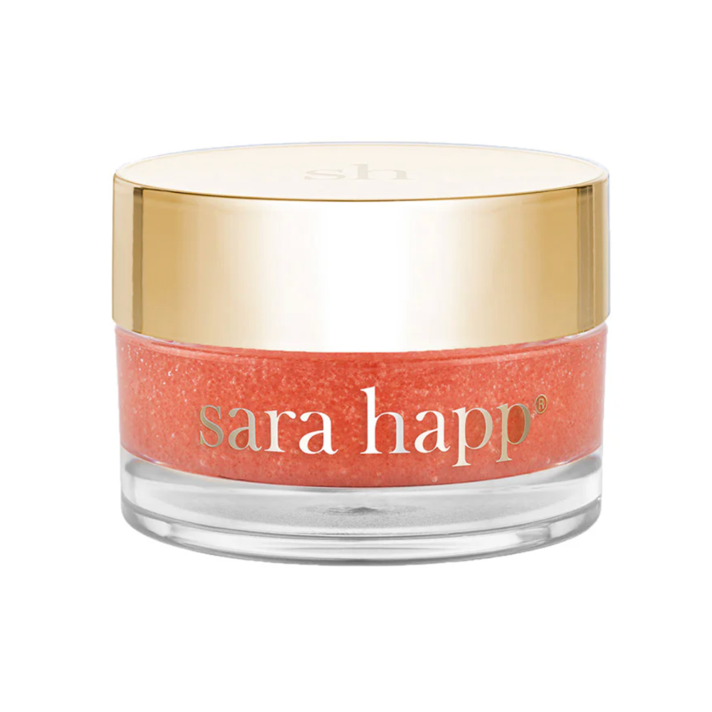 Close up of the Sara happ peach lip scrub with gold cap on.