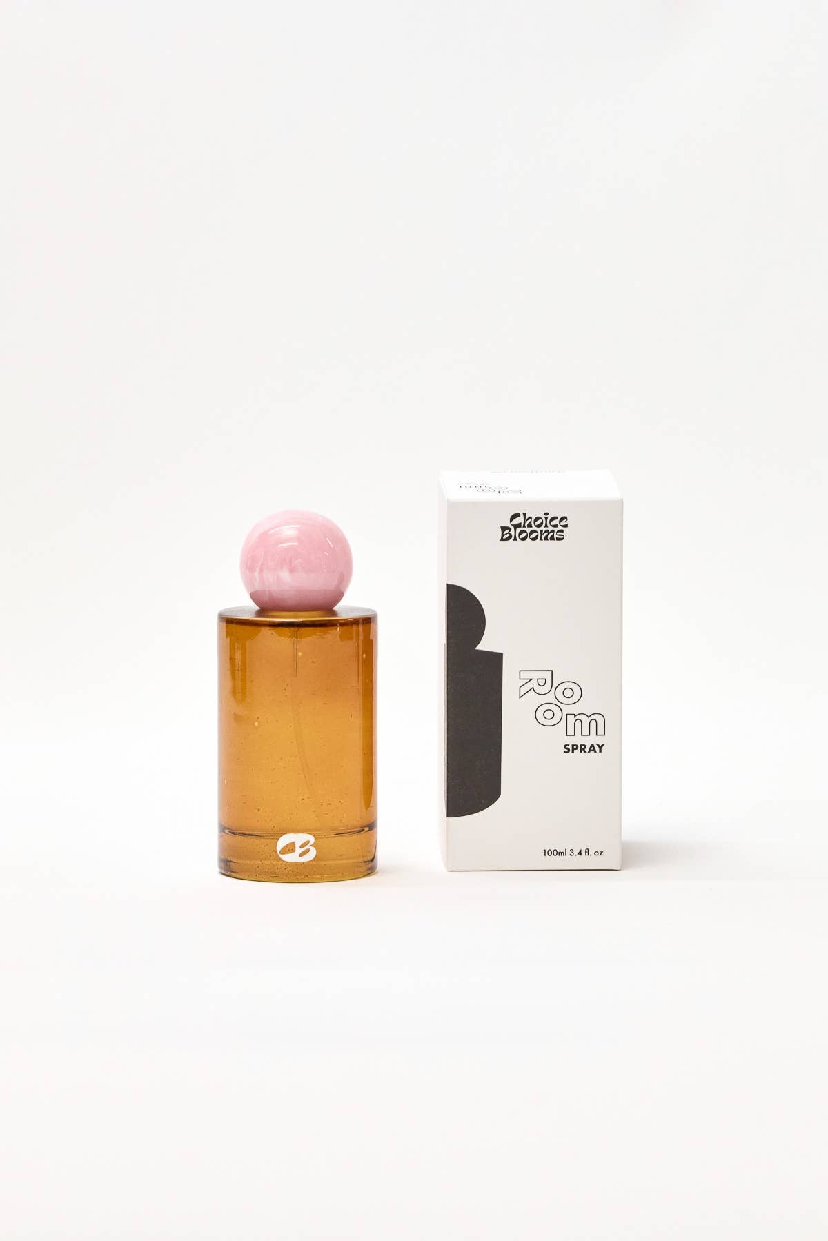 Amber perfume bottle with pink cap and white box on a white background