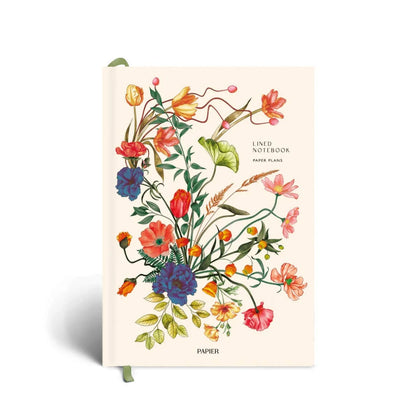 A lined notebook with a cream-colored cover featuring a colorful watercolor-style floral illustration, shown standing upright on a white background.